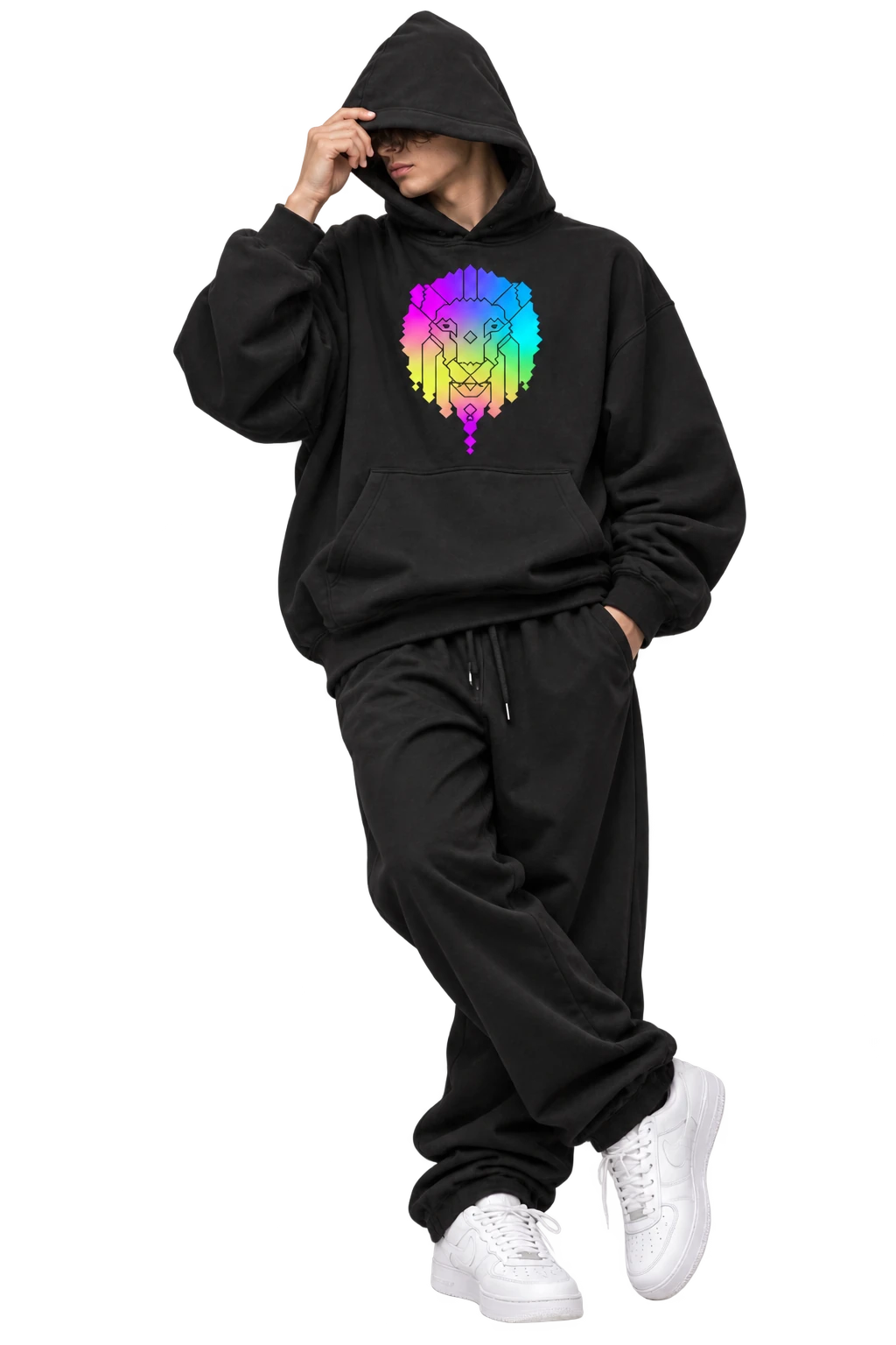 A model in a black ANML KNDM hoodie and sweatpants, hood up and one hand on the hood, with the rainbow lion on the chest